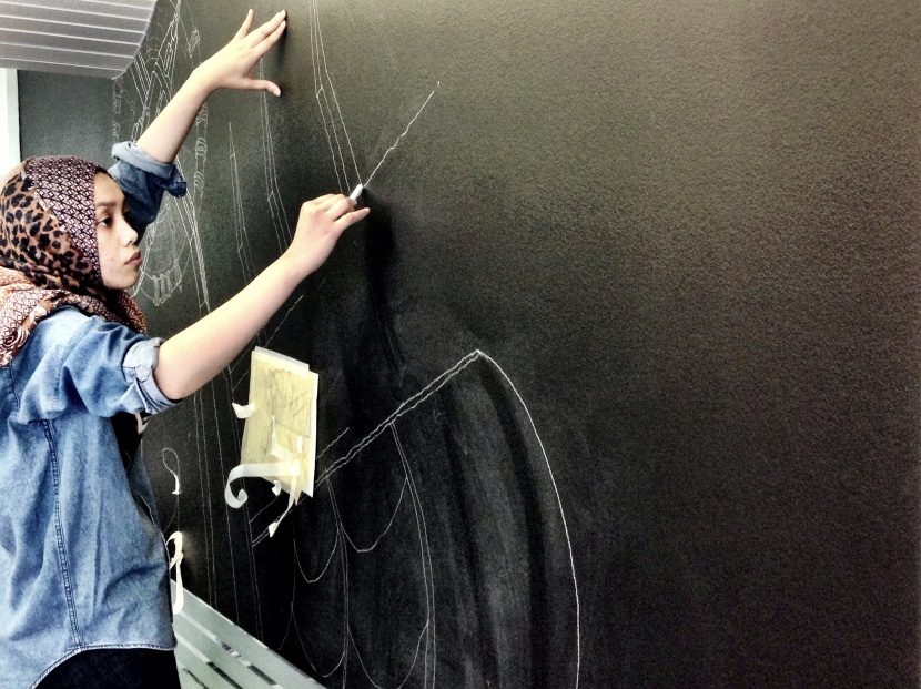 Shiela Samsuri from Westminster's Studio 14 working on a temporary mural drawing inside the bookshop